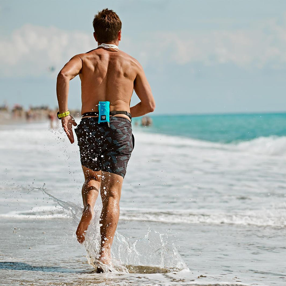 Loic Branda jogging through the water on the beach with Restube buoy on his belt