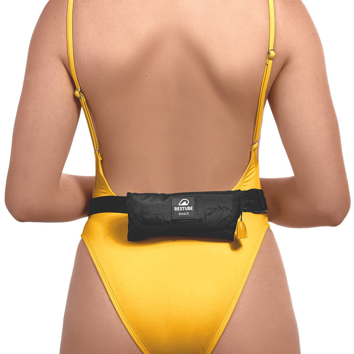 Woman in yellow swimsuit with restube beach worn on belt around waist