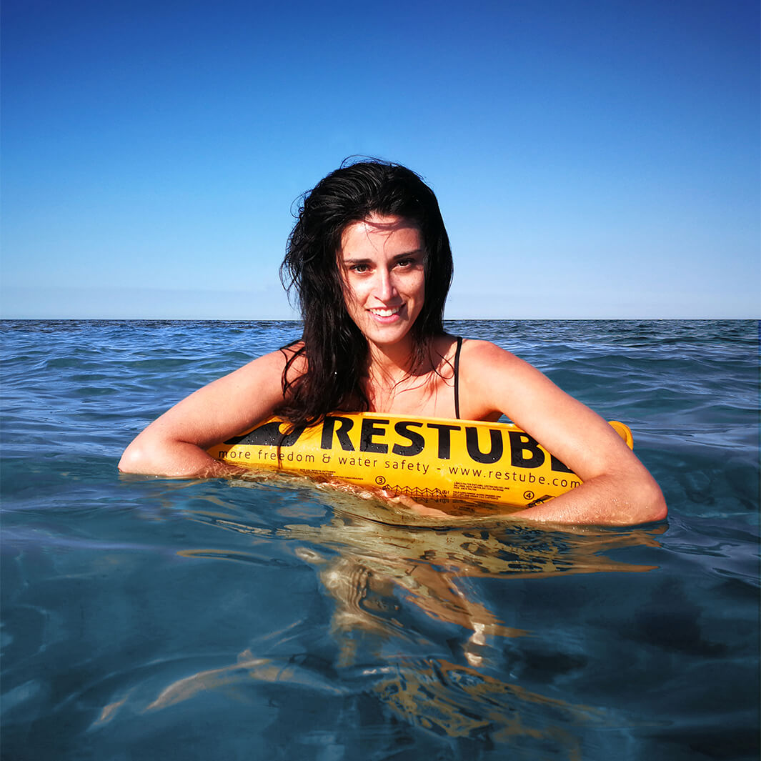 Woman floating on the water, leaning over a rest tube beach