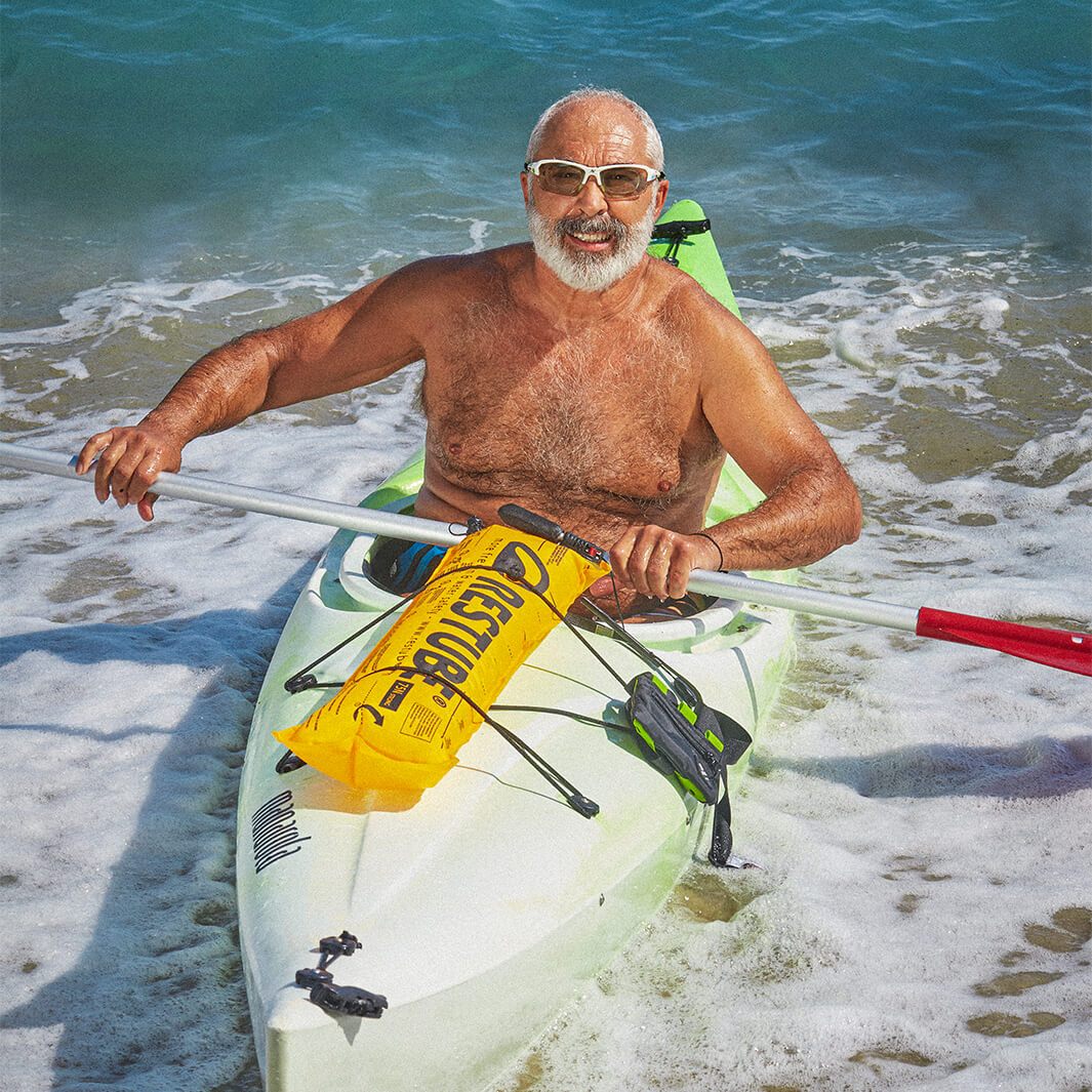 Man with sunglasses in kayak with restube swimming buoy fixed on it