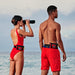 A lifeguard with binoculars, a lifeguard both with a restube lifeguard on the sea beach.